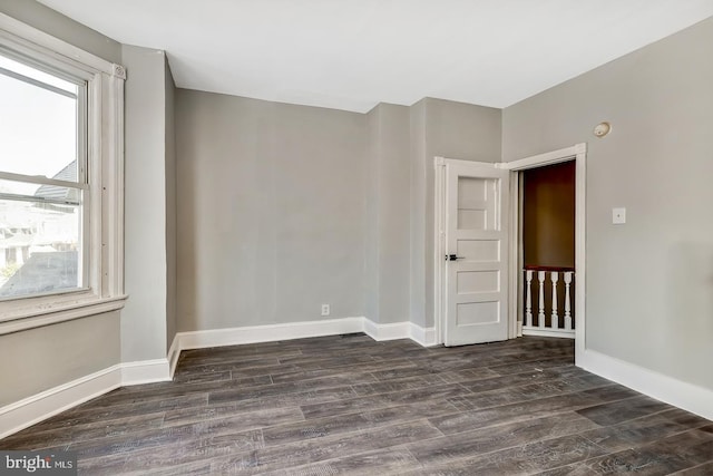 unfurnished room with dark hardwood / wood-style flooring