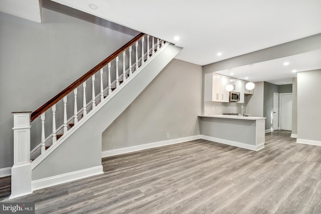 unfurnished living room featuring sink and hardwood / wood-style floors