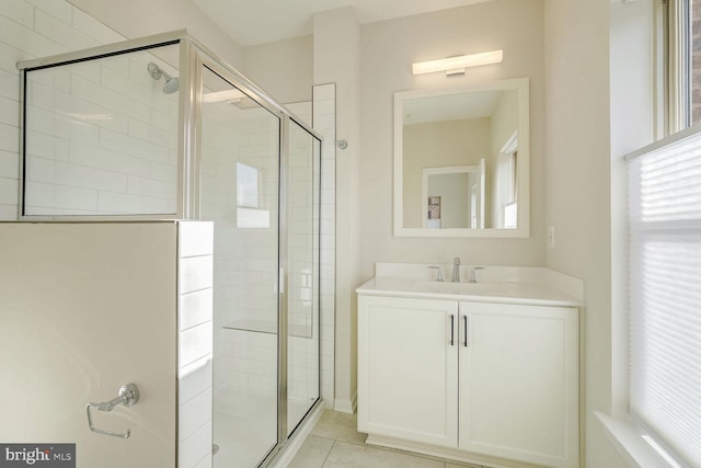 bathroom with tile patterned floors, vanity, and a shower with door