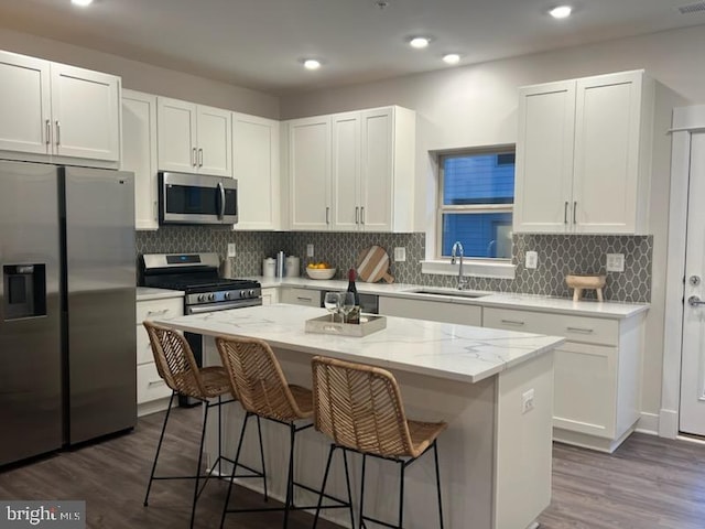 kitchen featuring white cabinets, sink, a kitchen island, and appliances with stainless steel finishes