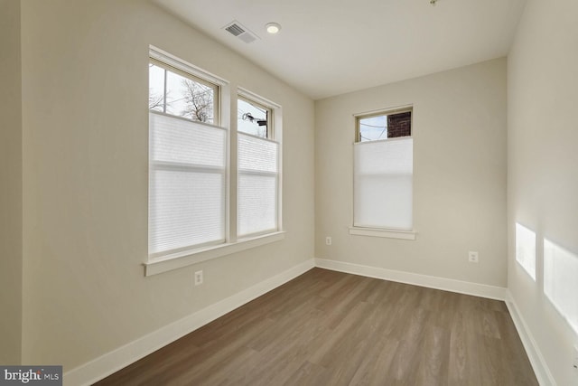 spare room featuring a wealth of natural light and hardwood / wood-style flooring