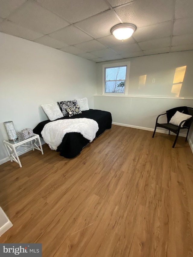 bedroom featuring hardwood / wood-style flooring and a drop ceiling