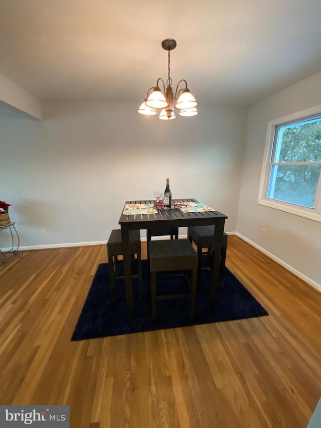 dining room featuring wood-type flooring and a notable chandelier