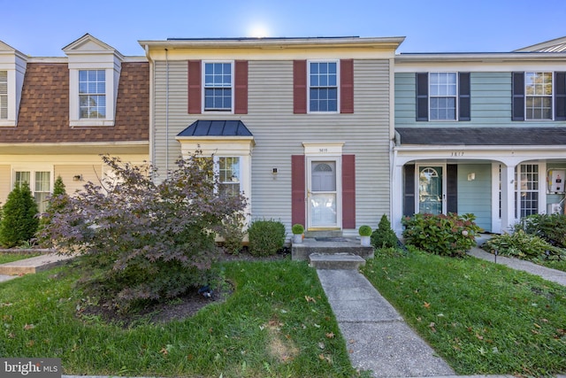 townhome / multi-family property featuring a front lawn