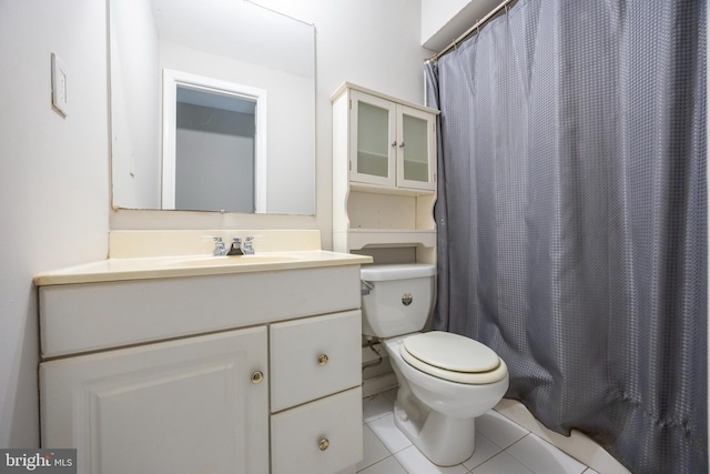 bathroom with vanity, curtained shower, toilet, and tile patterned flooring