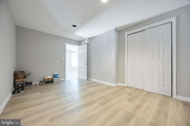 unfurnished bedroom with a closet and light wood-type flooring