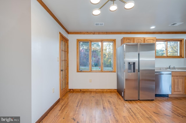 kitchen with appliances with stainless steel finishes, light wood-type flooring, a wealth of natural light, and light brown cabinetry