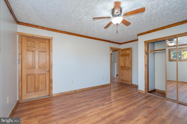 unfurnished bedroom with a closet, hardwood / wood-style flooring, ceiling fan, and ornamental molding