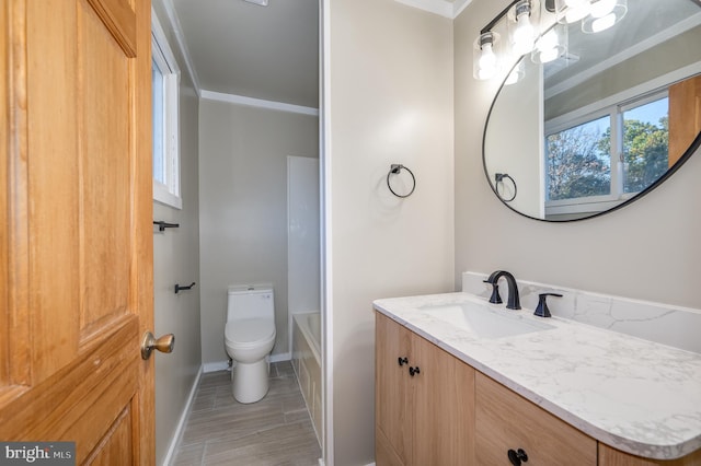 bathroom featuring vanity, toilet, and ornamental molding