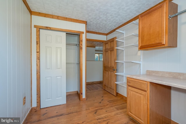 kitchen with light hardwood / wood-style floors and wooden walls