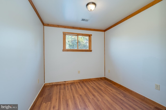 unfurnished room featuring hardwood / wood-style floors and ornamental molding