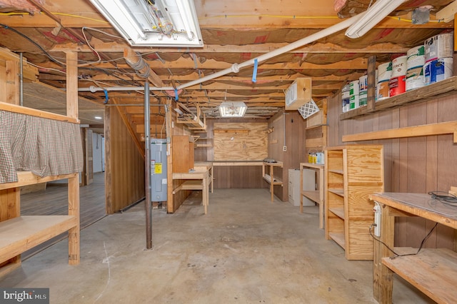 basement with wooden walls and water heater