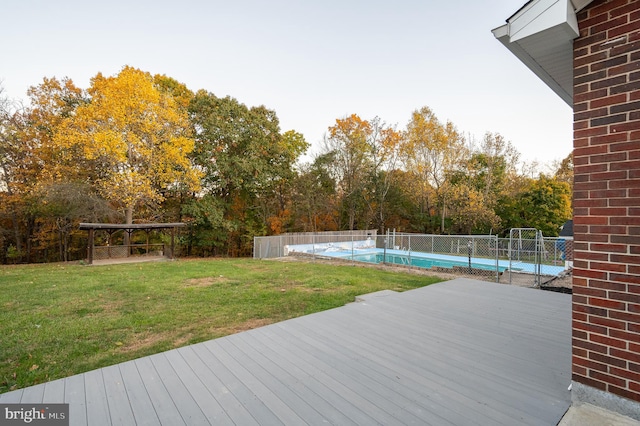 wooden deck with a lawn and a fenced in pool