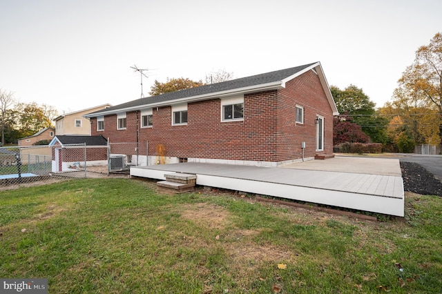 back of house with cooling unit, a deck, and a yard