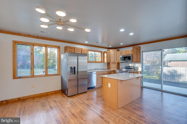 kitchen with a center island, a notable chandelier, light hardwood / wood-style floors, appliances with stainless steel finishes, and ornamental molding