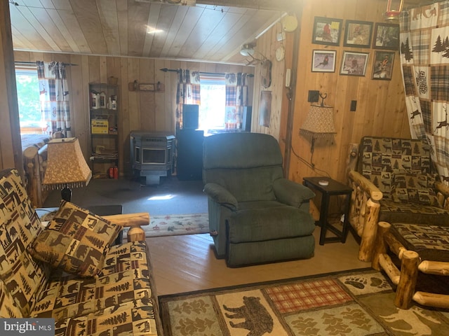 living room with wood ceiling, wood walls, a wood stove, and wood-type flooring