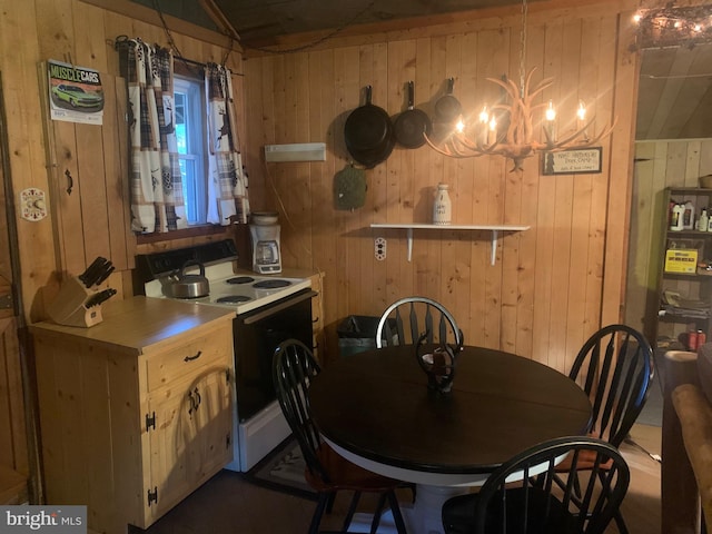 dining area featuring an inviting chandelier and wood walls