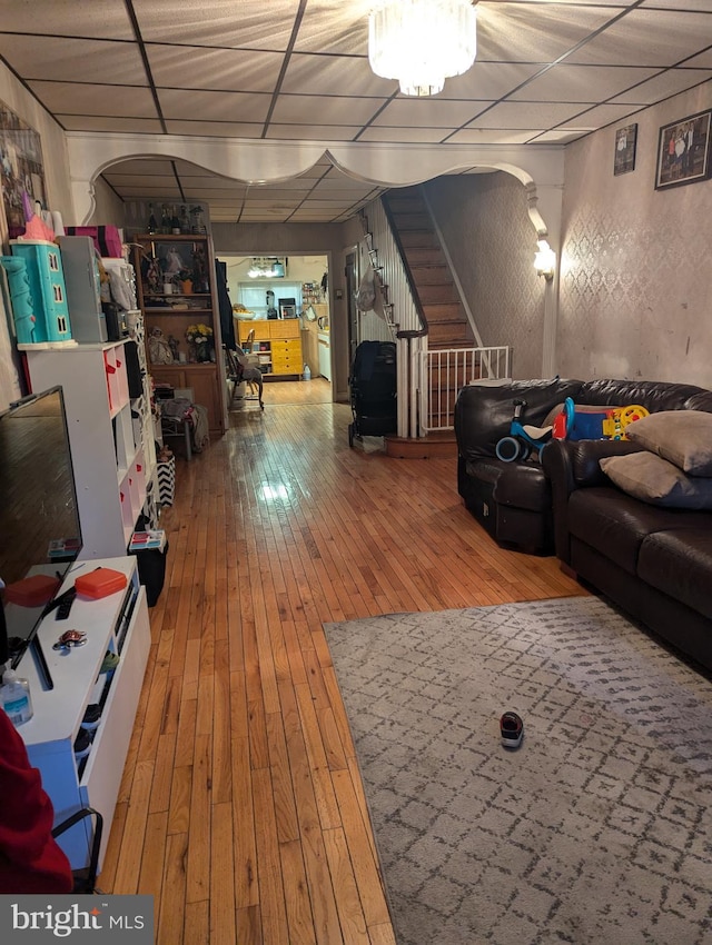 living room featuring hardwood / wood-style floors and a drop ceiling