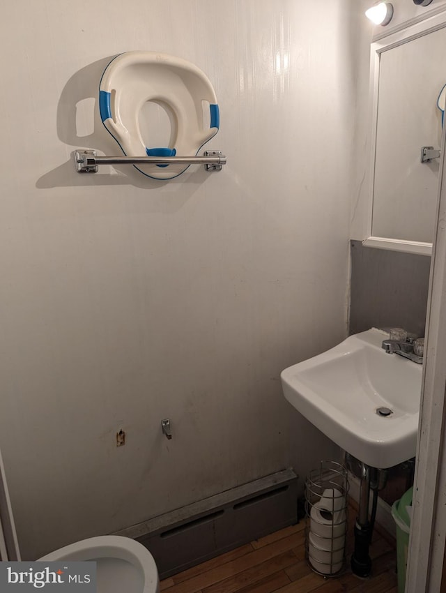 bathroom featuring toilet, sink, and hardwood / wood-style floors