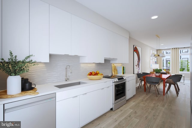 kitchen with sink, electric range, hanging light fixtures, light hardwood / wood-style floors, and white cabinets