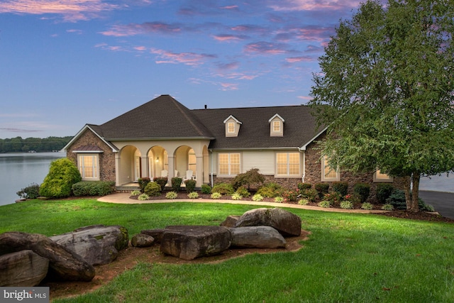 view of front of property featuring a lawn and a water view