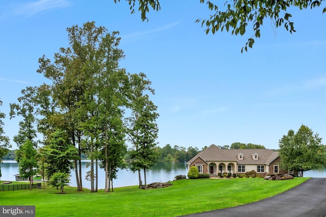 view of front facade with a water view and a front lawn