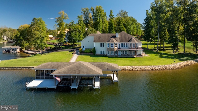 dock area with a lawn and a water view