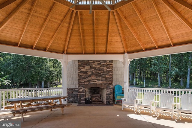 view of patio / terrace featuring a gazebo and an outdoor stone fireplace