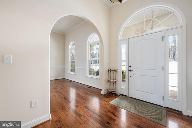 entrance foyer featuring dark wood-type flooring and ornamental molding