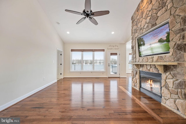 unfurnished living room featuring a fireplace, wood-type flooring, ceiling fan, and lofted ceiling