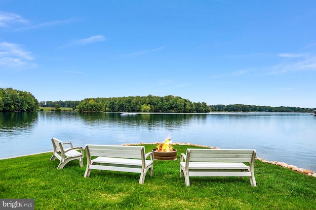 exterior space with a yard, a water view, and a fire pit