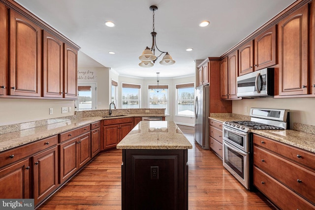 kitchen featuring pendant lighting, sink, a notable chandelier, a kitchen island, and stainless steel appliances