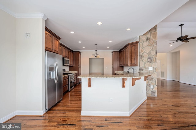 kitchen with a breakfast bar area, ceiling fan, light stone countertops, kitchen peninsula, and stainless steel appliances