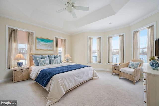 carpeted bedroom featuring a tray ceiling, ceiling fan, and ornamental molding