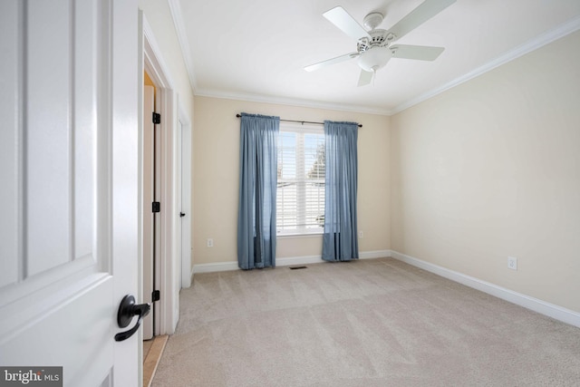 unfurnished room featuring light colored carpet, ceiling fan, and crown molding