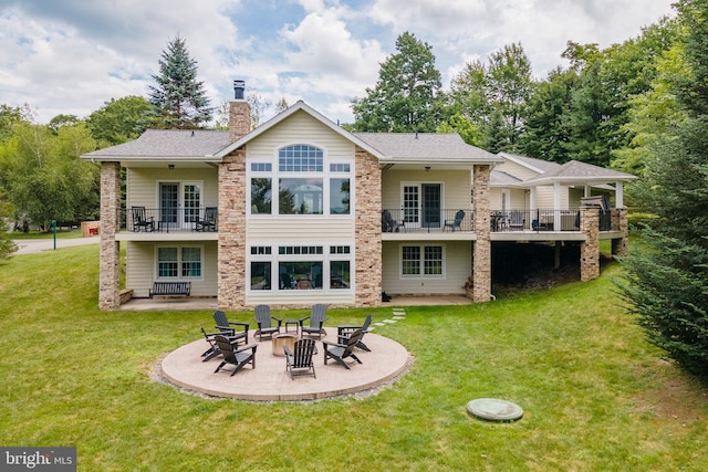 back of property featuring an outdoor fire pit, a patio area, and a lawn