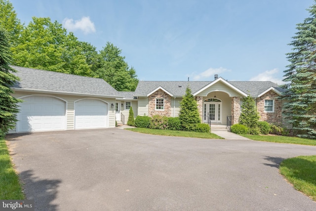 428 Pinnacle Dr, Swanton, MD 21561 - ranch-style home with a shingled roof, a garage, driveway, stone siding, and french doors