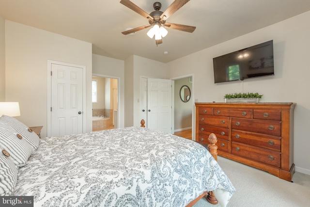 bedroom featuring light carpet, connected bathroom, and ceiling fan