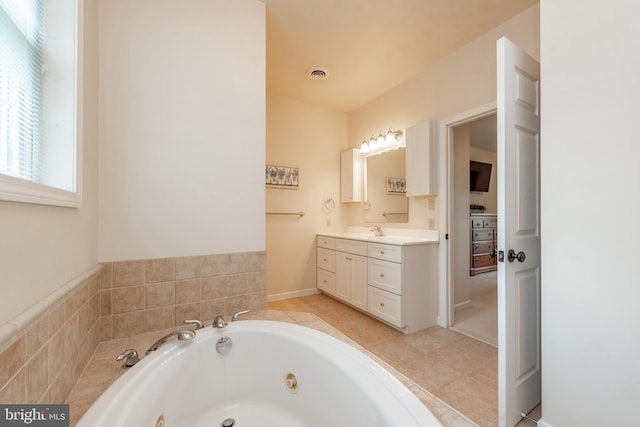 bathroom featuring vanity, tiled tub, and tile patterned flooring