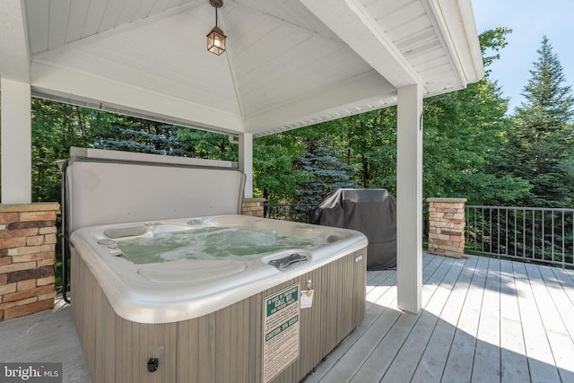 deck featuring area for grilling, a hot tub, cooling unit, and a gazebo