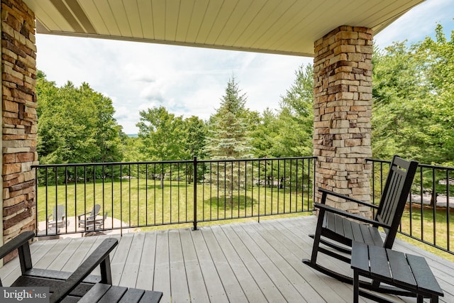 wooden terrace featuring a lawn