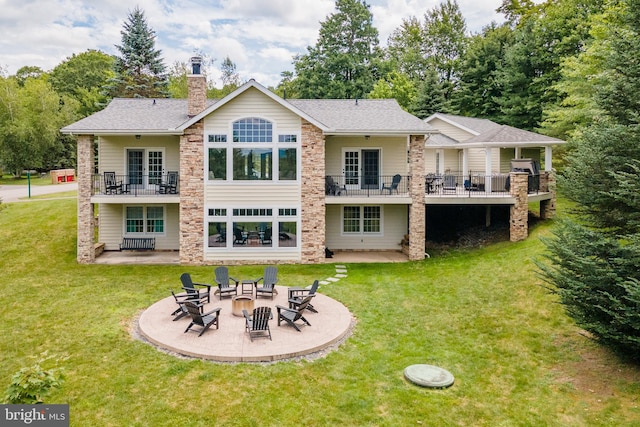 back of house featuring a patio area, a fire pit, and a yard