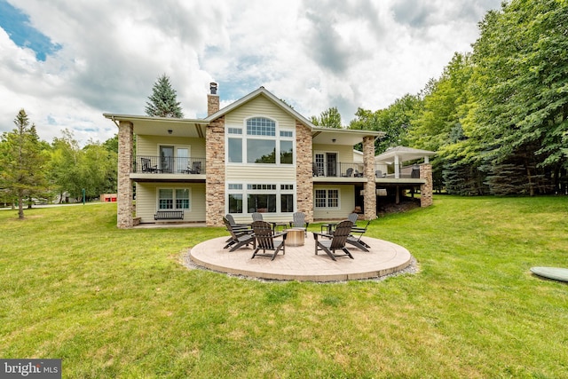 rear view of house featuring a patio area, a yard, and a balcony