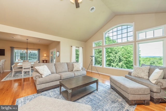 living room featuring high vaulted ceiling, light hardwood / wood-style floors, and ceiling fan