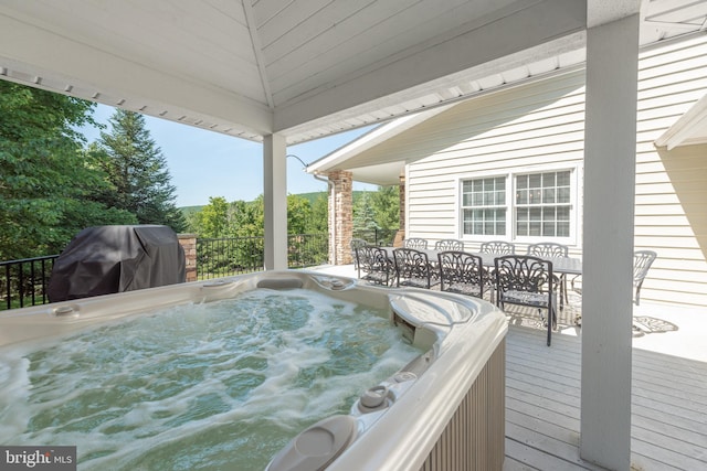 deck with a hot tub and grilling area