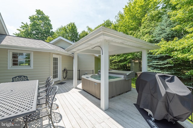 wooden terrace featuring a hot tub and area for grilling