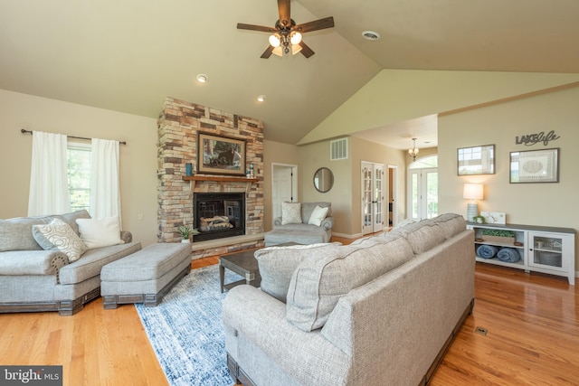 living room featuring hardwood / wood-style floors, a fireplace, high vaulted ceiling, and ceiling fan