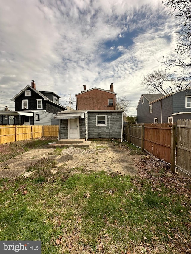 back of property featuring a fenced backyard and a chimney