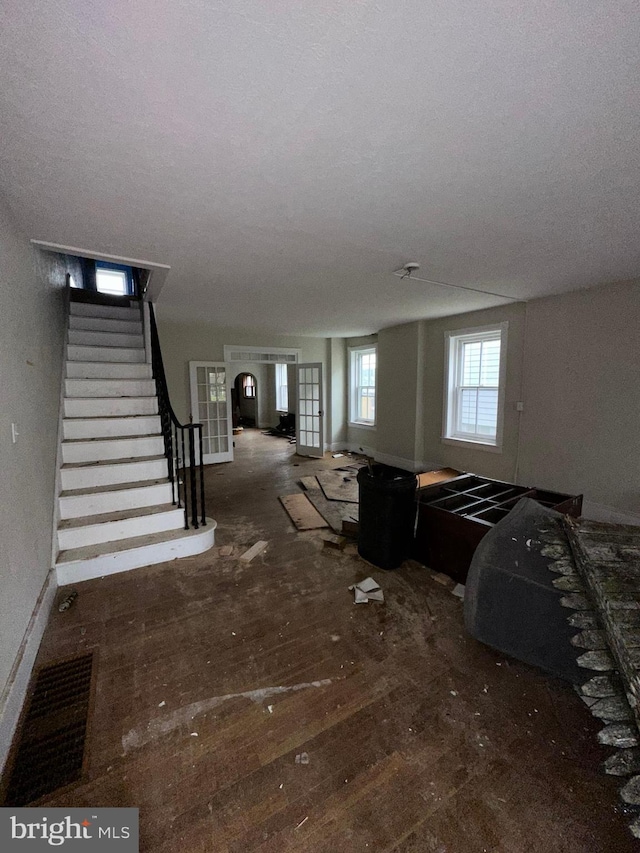 living area with baseboards and stairway