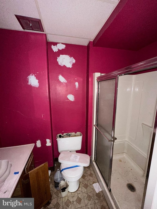 bathroom featuring vanity, a shower with shower door, and toilet